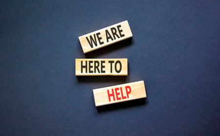 Support, help and we are here to help symbol. Concept words We are here to help on beautiful wooden blocks. Beautiful black background. Business we are here to help concept. Copy space.の写真素材
