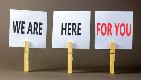 Support, help and we are here for you symbol. Concept words We are here for you on beautiful white papers on clothespin. Beautiful gray background. Business we are here for you concept. Copy space.の写真素材