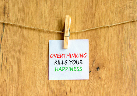 Overthinking kills your happiness symbol. Concept words Overthinking kills your happiness on white paper. Beautiful wooden background. Business overthinking kills happiness concept. Copy space.の写真素材