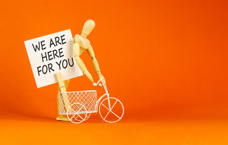 Support, help and we are here for you symbol. Concept words We are here for you on beautiful paper. Beautiful orange background. Businessman's model. Business we are here for you concept. Copy space.の写真素材