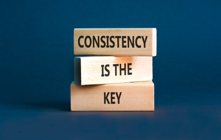Consistency is the key symbol. Concept words Consistency is the key on beautiful wooden blocks. Beautiful gray background. Business consistency is the key concept. Copy space.の写真素材