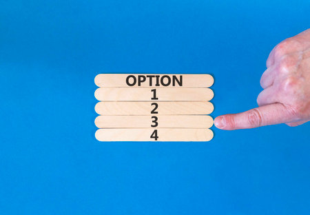Time to option 3 symbol. Concept word Option 1 2 3 4 on beautiful wooden sticks. Businessman's hand. Beautiful blue background. Business planning and time to option 3 concept. Copy space.の写真素材