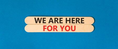Support, help and we are here for you symbol. Concept words We are here for you on beautiful wooden sticks. Beautiful blue background. Business we are here for you concept. Copy space.の写真素材