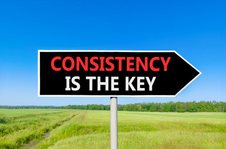 Consistency is the key symbol. Concept words Consistency is the key on beautiful black road sign....