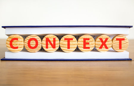 Context symbol. Concept word Context on beautiful wooden circles in book. Beautiful wooden table white background. Business context concept. Copy space.の写真素材