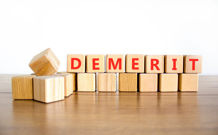 Demerit symbol. Concept word Demerit on beautiful wooden blocks. Beautiful wooden table white background. Business demerit concept. Copy space.の写真素材