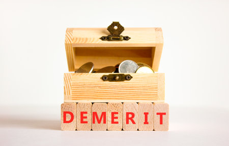 Demerit symbol. Concept word Demerit on beautiful wooden blocks. Beautiful white background. Beautiful wooden chest with coins. Business demerit concept. Copy space.の写真素材