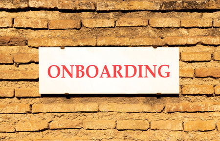 Onboarding success symbol. Concept word Onboarding on beautiful white marble sign plate. Beautiful ancient brick wall background. Business onboarding success concept. Copy space.の写真素材