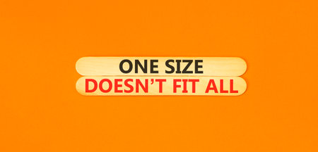 One size does not fit all symbol. Concept words One size does not fit all on beautiful wooden sticks. Beautiful orange background. Business one size does not fit all concept. Copy space.の写真素材