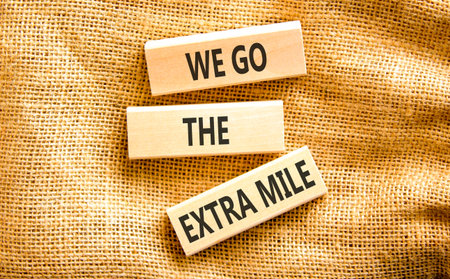 Support, help we go the extra mile symbol. Concept words We go the extra mile on beautiful wooden...