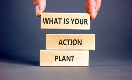 What is your action plan symbol. Concept words What is your action plan on beautiful blocks. Beautiful gray background. Businessman's hand. Business what is your action plan concept. Copy space.の写真素材