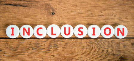 Inclusion symbol. Concept words Inclusion on beautiful white circles. Beautiful wooden background. Business support inclusion concept. Copy space.の写真素材