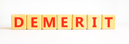 Demerit symbol. Concept word Demerit on beautiful wooden blocks. Beautiful white background. Business demerit concept. Copy space.の写真素材