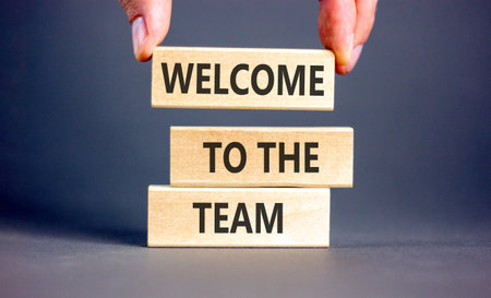 Support, help welcome to the team symbol. Concept words Welcome to the team on beautiful wooden blocks. Beautiful gray background. Businessman's hand. Business welcome to team concept. Copy space.の写真素材