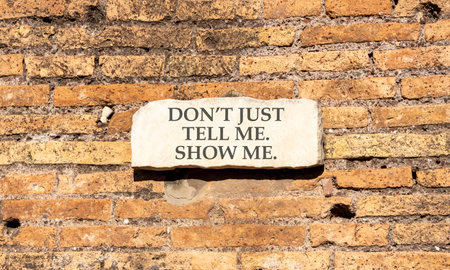 Tell or show symbol. Concept words Do not just tell me, show me beautiful white marble sign plate. Beautiful brick wall background. Business tell or show concept. Copy space.の写真素材