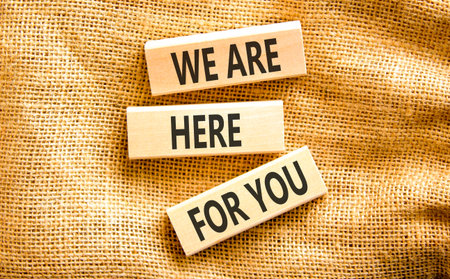 Support, help and we are here for you symbol. Concept words We are here for you on beautiful wooden blocks. Beautiful canvas background. Business we are here for you concept. Copy space.の写真素材