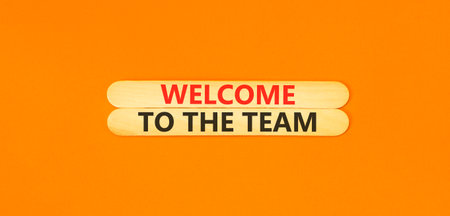 Support, help welcome to the team symbol. Concept words Welcome to the team on beautiful wooden sticks. Beautiful orange background. Business welcome to the team concept. Copy space.の写真素材