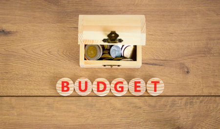 Budget symbol. Concept word Budget on beautiful wooden circles. Beautiful wooden background. Beautiful wooden chest with coins. Business budget concept. Copy space.の写真素材