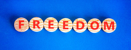 Freedom support symbol. Concept word Freedom on beautiful wooden circles. Beautiful blue background....