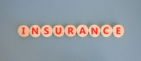Insurance symbol. Concept words Insurance on beautiful wooden circles. Beautiful gray background....