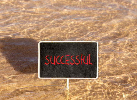 Successful symbol. Concept word Successful on beautiful black blackboard. Beautiful Red sea water background. Business successful concept. Copy space.の写真素材