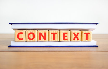 Context symbol. Concept word Context on beautiful wooden blocks in book. Beautiful wooden table...