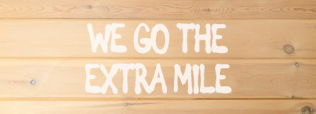 Support, help we go the extra mile symbol. Concept words We go the extra mile on beautiful wooden wall. Beautiful wooden wall background. Business we go the extra mile concept. Copy space.の写真素材