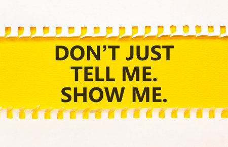 Tell or show symbol. Concept words Do not just tell me, show me on beautiful yellow paper. Beautiful white paper background. Business tell or show concept. Copy space.の写真素材