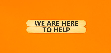 Support, help and we are here to help symbol. Concept words We are here to help on beautiful wooden sticks. Beautiful orange background. Business we are here to help concept. Copy space.の写真素材