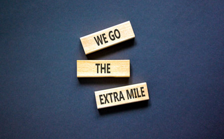 Support, help we go the extra mile symbol. Concept words We go the extra mile on beautiful wooden blocks. Beautiful black background. Business we go the extra mile concept. Copy space.の写真素材