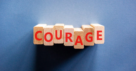 Courage symbol. Concept word Courage on beautiful wooden blocks. Beautiful blue background. Business courage concept. Copy space.の写真素材
