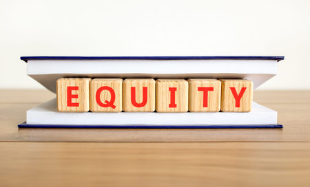 Equity support and help symbol. Concept word Equity on wooden blocks in book. Wooden table white background. Business equity support and help concept. Copy space.の写真素材