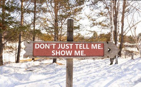 Tell or show symbol. Concept words Do not just tell me, show me wooden road sign. Beautiful winter forest background. Business tell or show concept. Copy space.の写真素材