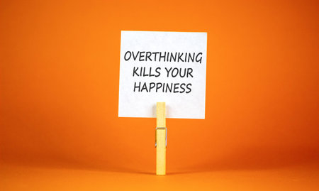 Overthinking kills your happiness symbol. Concept words Overthinking kills your happiness on white paper. Beautiful orange background. Business overthinking kills happiness concept. Copy space.の写真素材