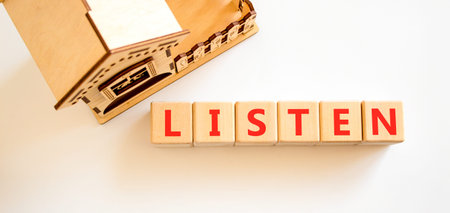 Listen symbol. Concept Listen word on beautiful wooden blocks. Beautiful white background. Beautiful wooden model of house. Business education listen concept. Copy space.の写真素材