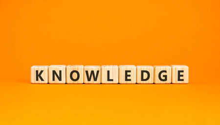 Knowledge symbol. Concept word Knowledge on beautiful wooden blocks. Beautiful orange background....