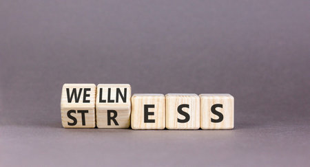 Wellness or stress symbol. Concept words Wellness or Stress on beautiful wooden cubes. Beautiful...