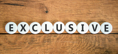 Exclusive symbol. Concept words Exclusive on beautiful white circles. Beautiful wooden background....