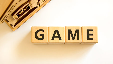 Game symbol. Concept word Game on beautiful wooden blocks. Beautiful wooden house. Beautiful white table white background. Business, lifestyle and game concept. Copy space.の写真素材