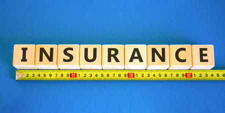 Insurance symbol. Concept words Insurance on beautiful wooden blocks. Beautiful blue background. Beautiful yellow ruler. Business support medical insurance concept. Copy space.の写真素材
