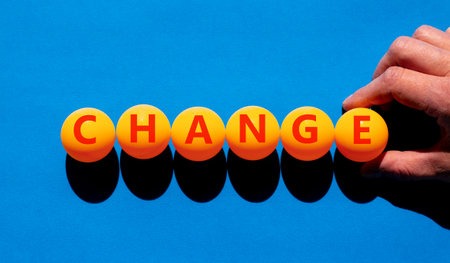 Change symbol. Concept word Change on beautiful orange table tennis ping pong balls. Beautiful blue background. Businessman's hand. Business change concept. Copy space.の写真素材