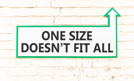 One size does not fit all symbol. Concept words One size does not fit all on beautiful white sign plate. Beautiful brick wall background. Business one size does not fit all concept. Copy space.の写真素材