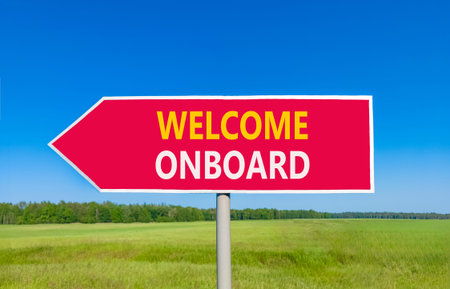 Welcome onboard symbol. Concept words Welcome onboard on beautiful red road sign. Beautiful blue sky green grass field background. Business, motivational welcome onboard concept. Copy space.の写真素材