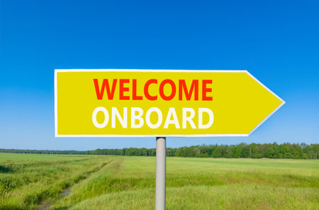 Welcome onboard symbol. Concept words Welcome onboard on beautiful yellow road sign. Beautiful blue sky green grass field background. Business, motivational welcome onboard concept. Copy space.の写真素材