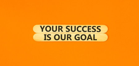 Your success is our goal symbol. Concept words Your success is our goal on beautiful wooden sticks. Beautiful orange background. Business your success is our goal concept. Copy space.の写真素材
