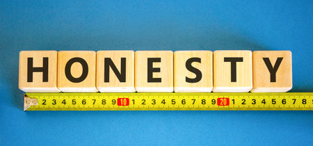 Honesty word symbol. Concept word Honesty on beautiful wooden blocks. Beautiful blue background. Beautiful yellow ruler. Business honesty concept. Copy space.の写真素材