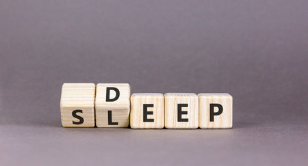 Deep sleep symbol. Concept words Deep sleep on beautiful wooden cubes. Beautiful gray table gray background. Beautiful gray table gray background. Healthy lifestyle, medical and deep sleep concept. Copy space.の写真素材