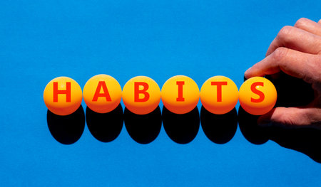Habits support and help symbol. Concept word Habits on beautiful orange table tennis ping pong balls. Beautiful blue background. Business psychological habits support and help concept. Copy space.の写真素材