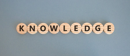 Knowledge symbol. Concept word Knowledge on beautiful wooden circles. Beautiful gray background....