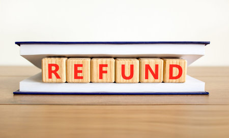 Refund word symbol. Concept word Refund on beautiful wooden blocks in beautiful book. Beautiful...